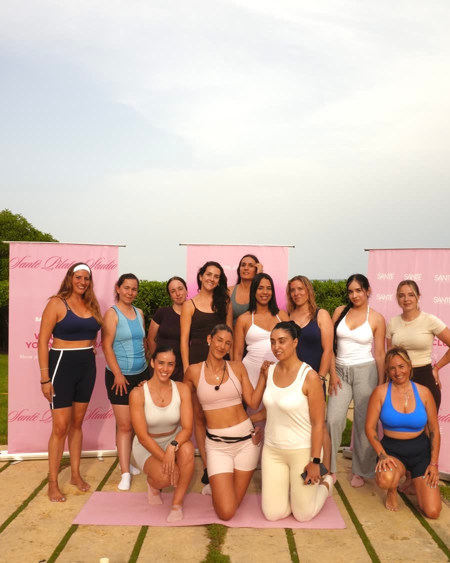 El grupo del evento posando delante de las pancartas de Santé