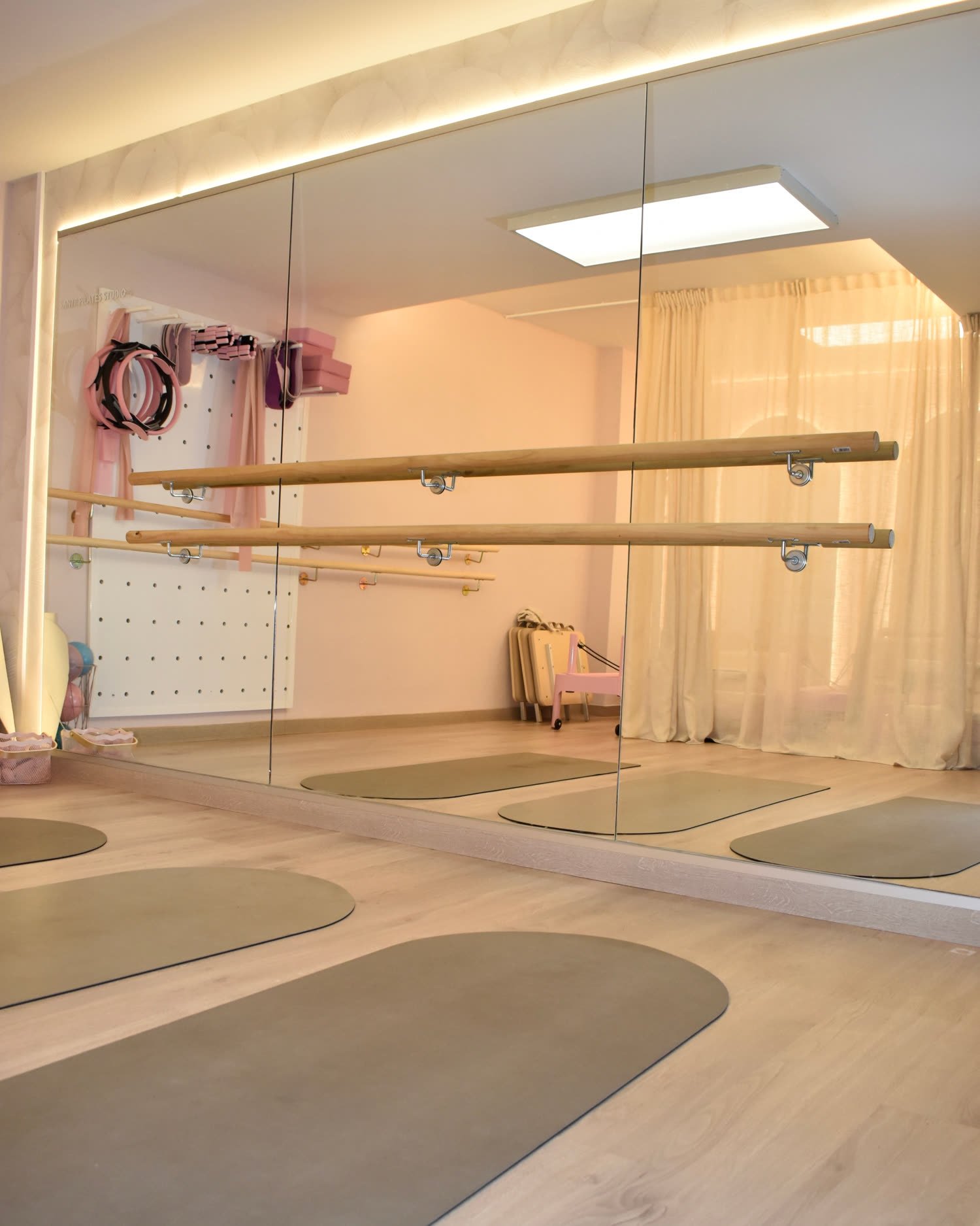 La sala de Mat y Barre, con la barra de madera, el espejo y las esterillas